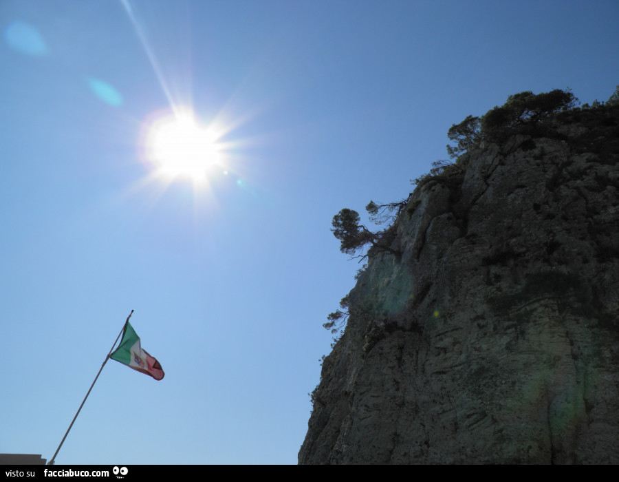 Bandiera italiana che sventola di fronte ad una roccia