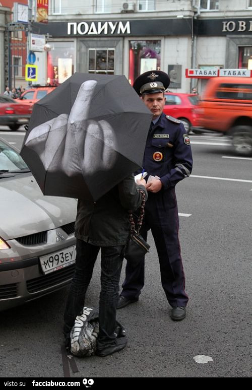 Dito medio sull'ombrello mentre parla col poliziotto