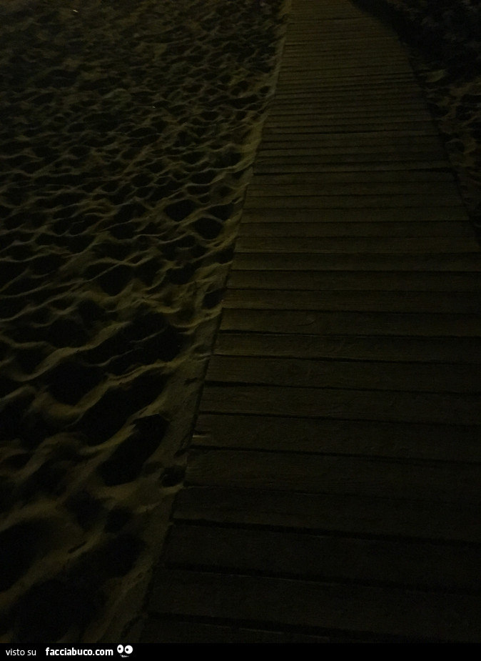 Sentiero in legno sulla spiaggia di notte