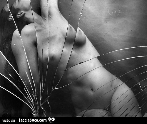 Donna nuda allo specchio in frantumi