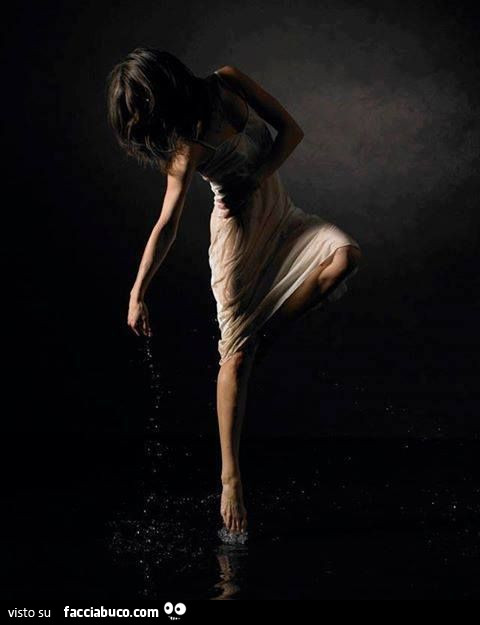 Ragazza bagnata danza sull'acqua