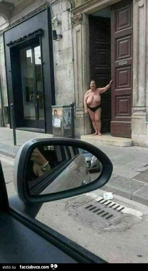 Donna grassa e nuda fuori dal portone di casa per strada